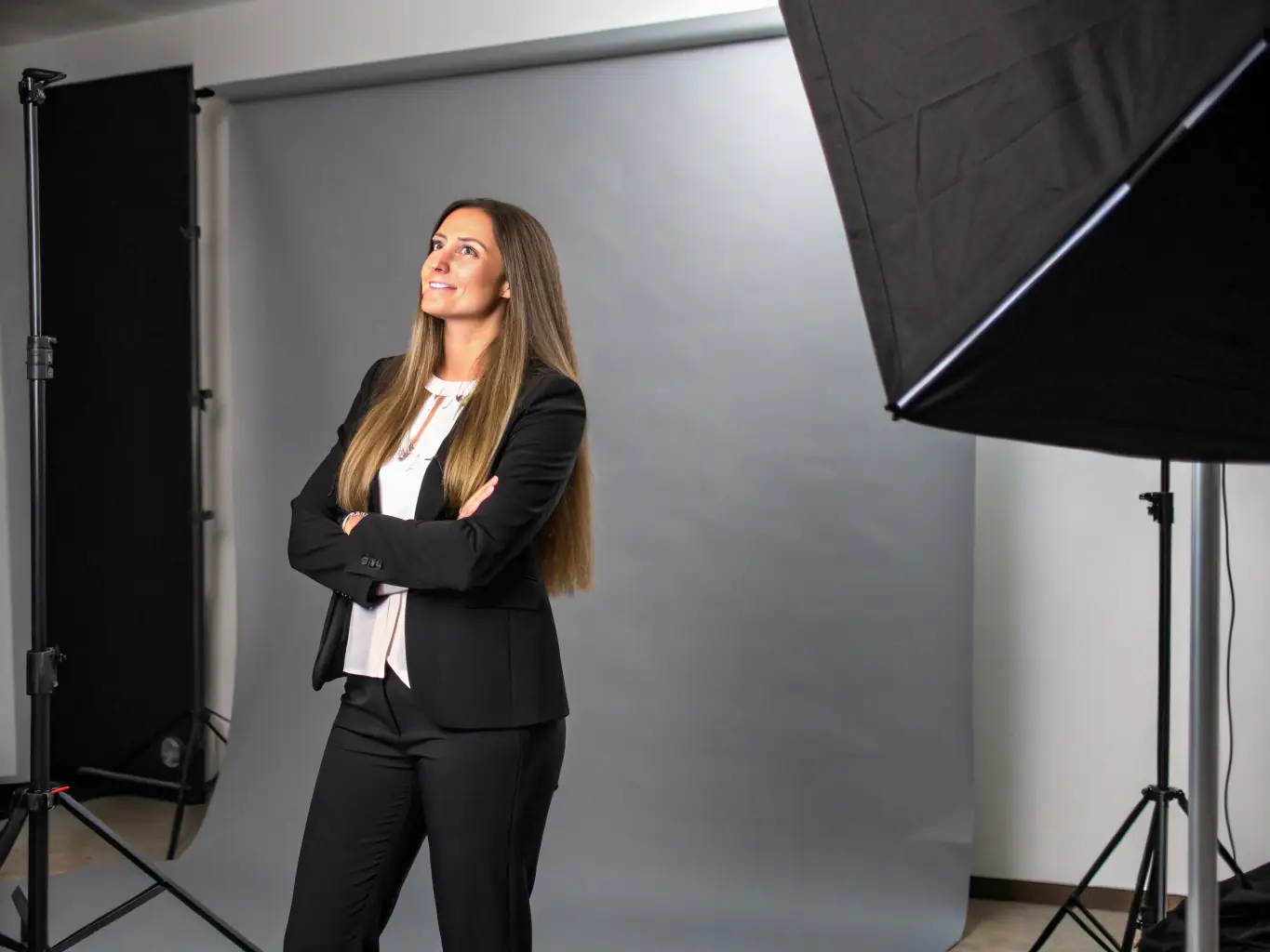 A professional influencer is posing for a photo shoot, showcasing a high-end fashion brand. The setting is a modern studio with soft, diffused lighting, emphasizing the quality and style of the clothing.